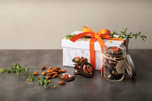 gift box wrapped in orange ribbon and almonds