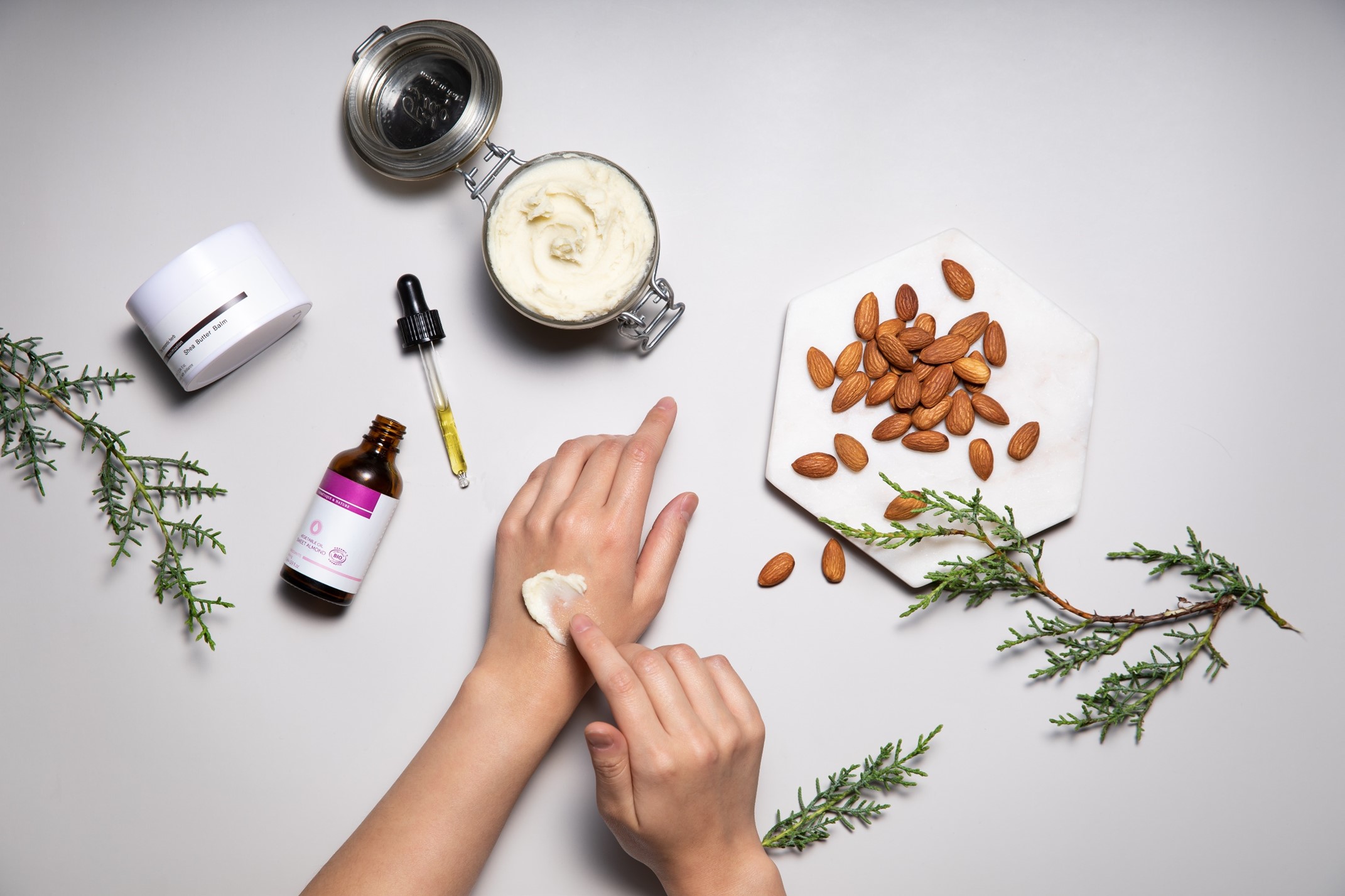 an image showing hands applying almond cream