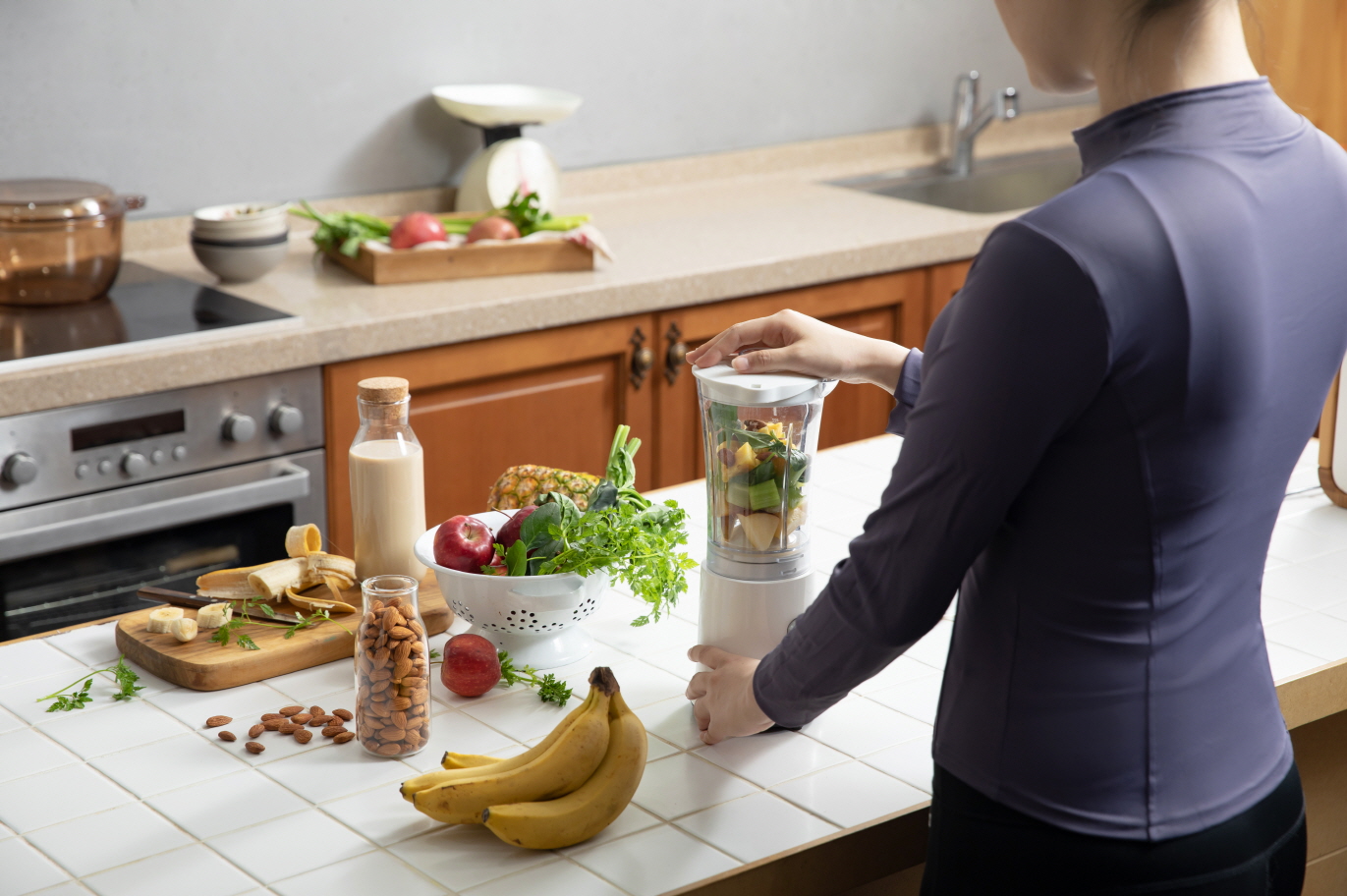 a woman making salad with almonds