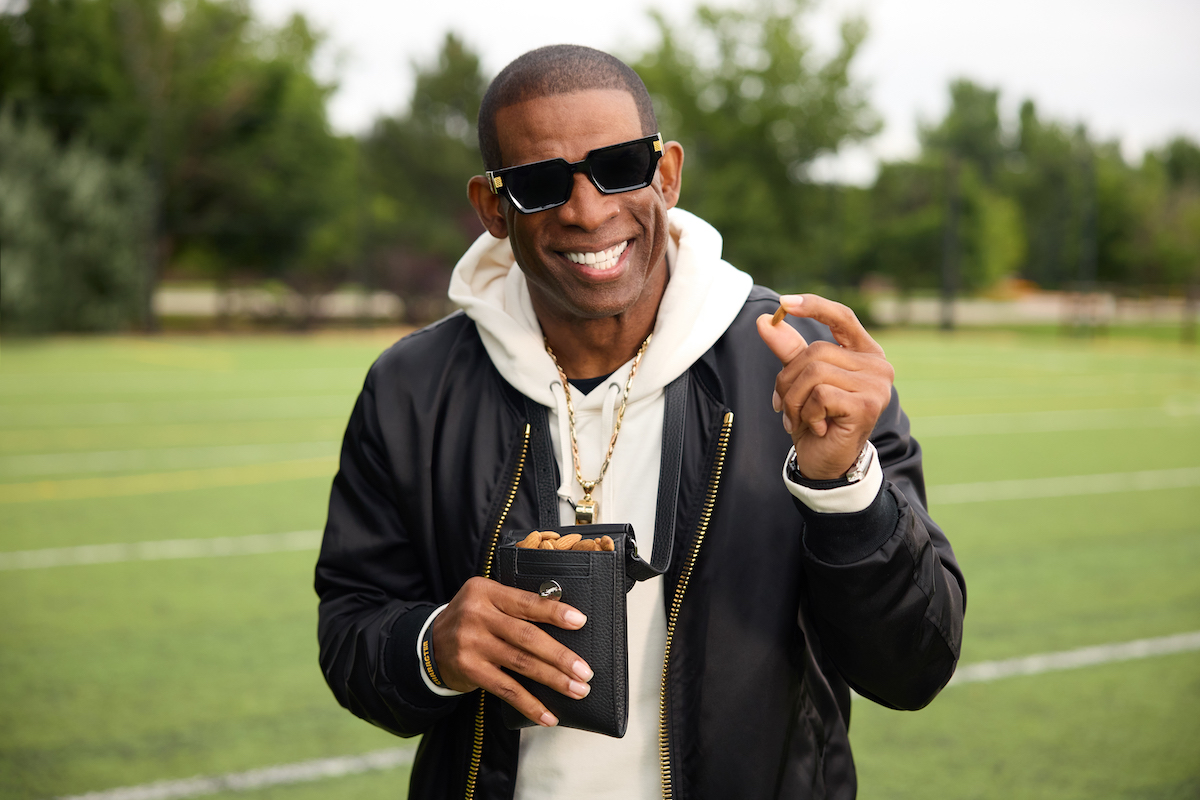 Man holding almonds on a sports field