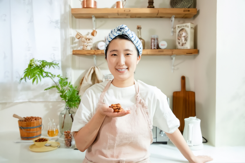 a woman holding almond bottle