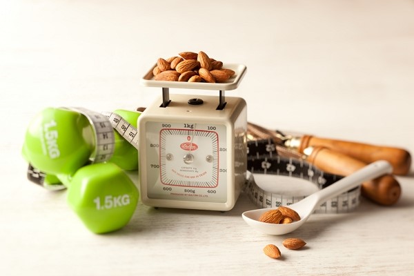 almonds on a scale with dumbells